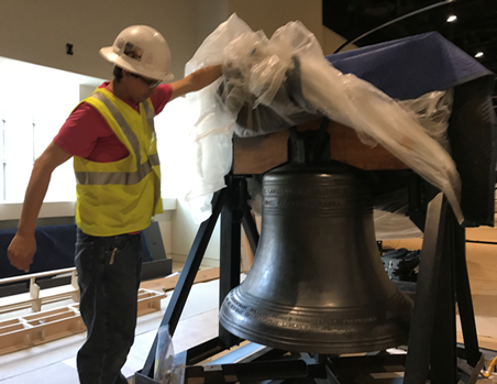 A worker unveils a liberty bell