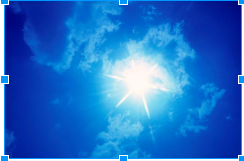 A look at the sun peering through a clear blue sky with fluffy white clouds