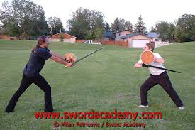 photo of weapons experts using sword and buckler in modern day combat'