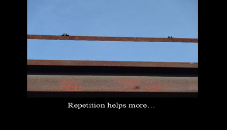 A black framed photo with the photo pulled further back so it looks like a possible overpass tressle with the words Repetition helps some written on the black frame